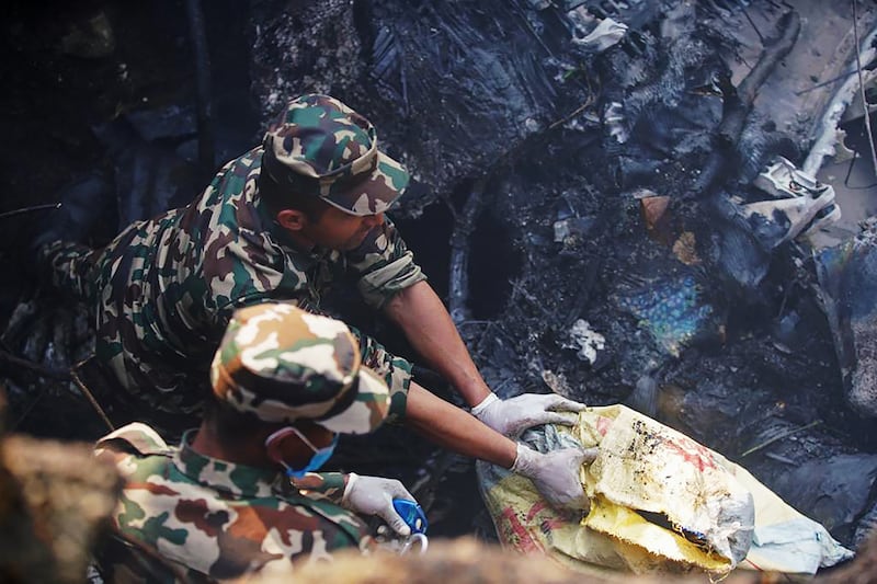 Rescuers at the site of a plane crash in Pokhara, Nepal. Photograph: Yunish Gurung/AFP via Getty