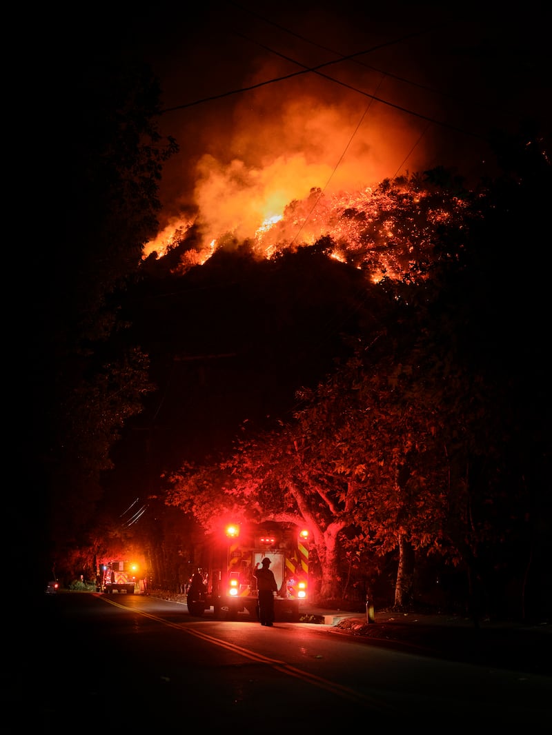 The hills burn above houses during the Palisades fire. Photograph: Philip Cheung/The New York Times