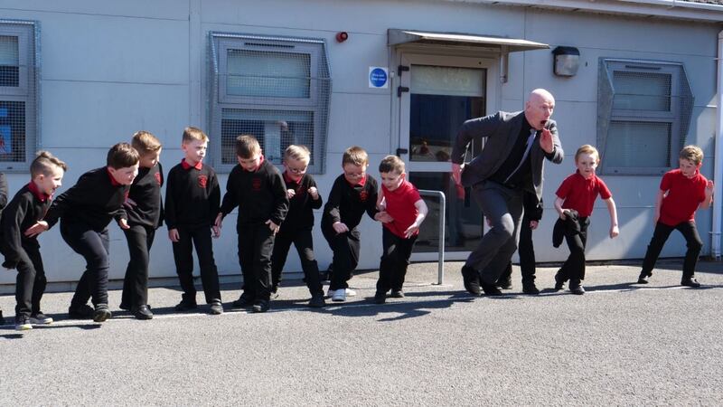 Kevin Mc Arevey, headmaster of Holy Cross Boys Primary School, with some of his junior philosophers in a scene from Young Plato. Image: Soilsiú Films