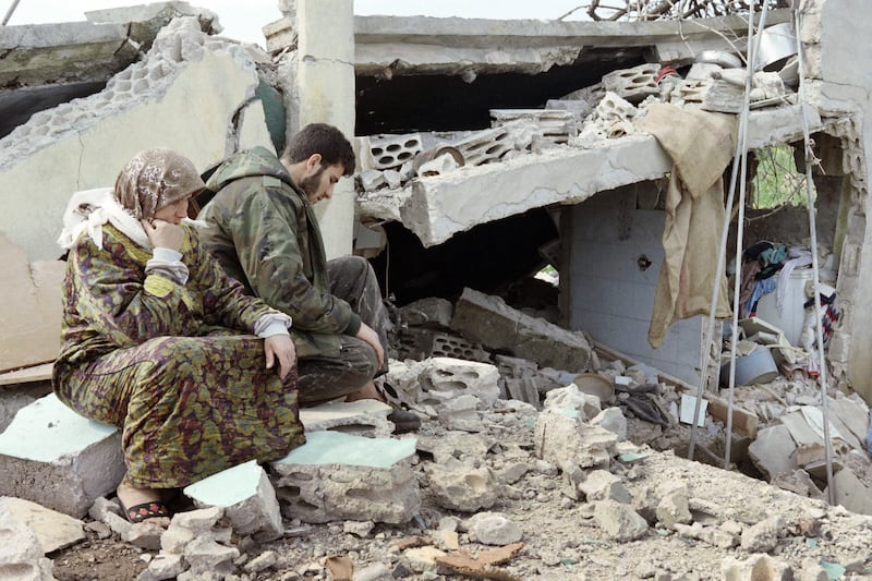 A Lebanese  Hizbullah fighter sits with his mother next to their destroyed home in Sidikine, South Lebanon, on April 28th, 1996.  Photograph: Ramzi Haidar/AFP via Getty Images