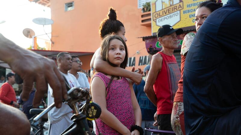 Residents at the scene where a young man was shot twice and killed by an assailant in Belém. Photograph: Tyler Hicks/The New York Times