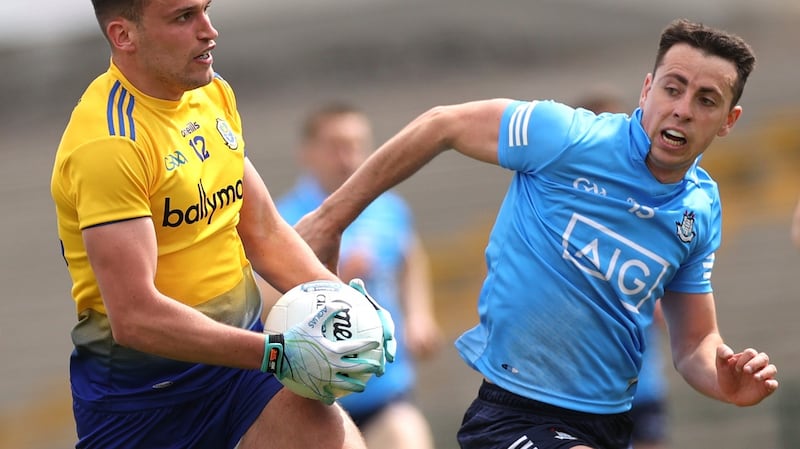 Enda Smith carries with Cormac Costello in pursuit in Roscommon’s defeat to Dublin. Photograph: James Crombie/Inopho