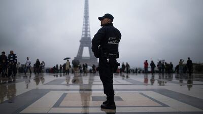 A French police officer patrols at Trocadero plaza with the Eiffel Tower in the background in Paris.