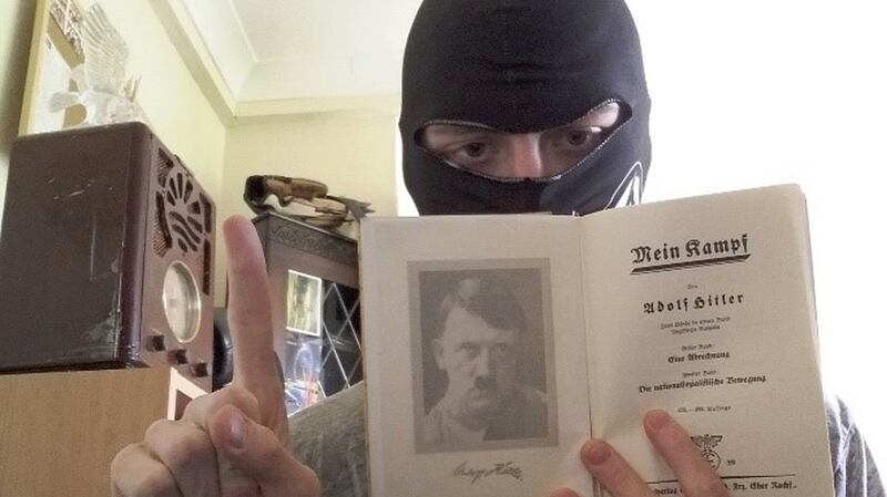 Mark Jones poses  with a copy of Hitler’s autobiography, Mein Kampf. Photograph: West Midlands Police/PA Wire.