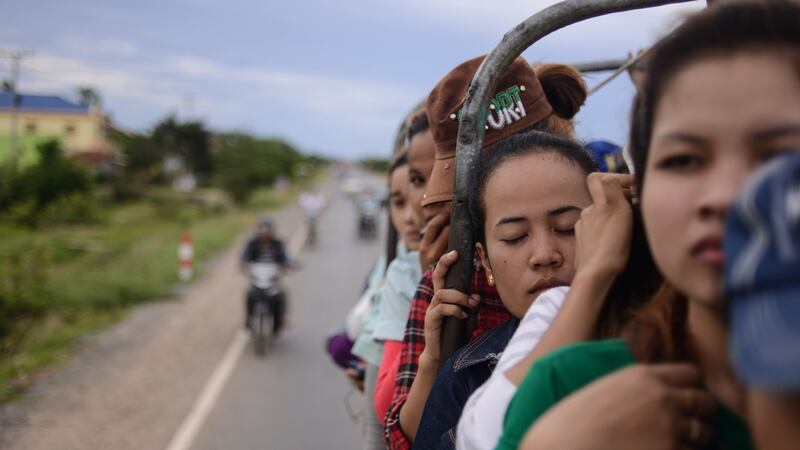 A garment worker catches a moment of shut-eye on the way home in an open-topped truck in Kompong Speu province in September 2014. Back then the monthly wage was $100, with workers risking a perilous journey to factories to produce clothes for big brands such as Gap and H&M. Photograph: Lauren Crothers