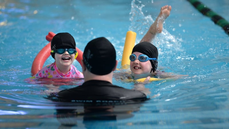 Olive and Grace Kavanagh with swimming instructor David Tyrrell. Photograph: Dara Mac Dónaill