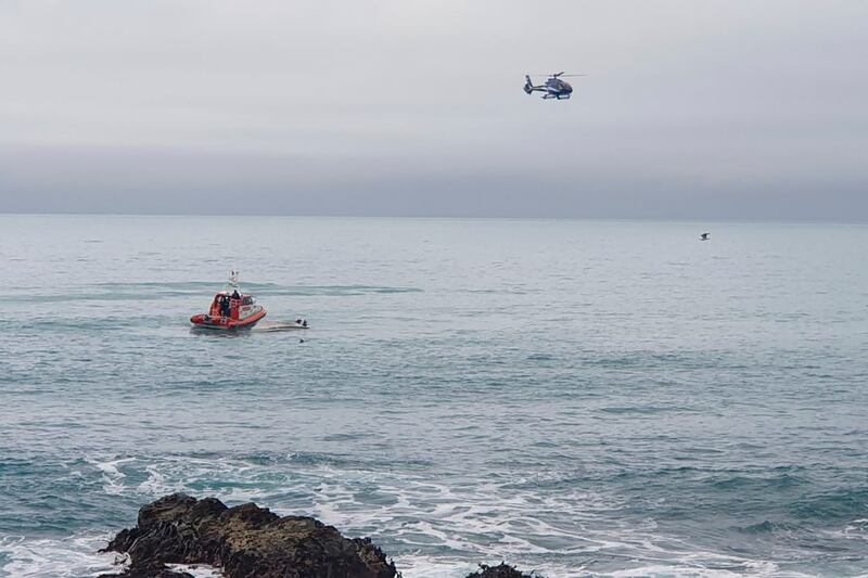 A helicopter and a rescue boat search for survivors off the coast of Kaikoura, New Zealand. Photograph: AP