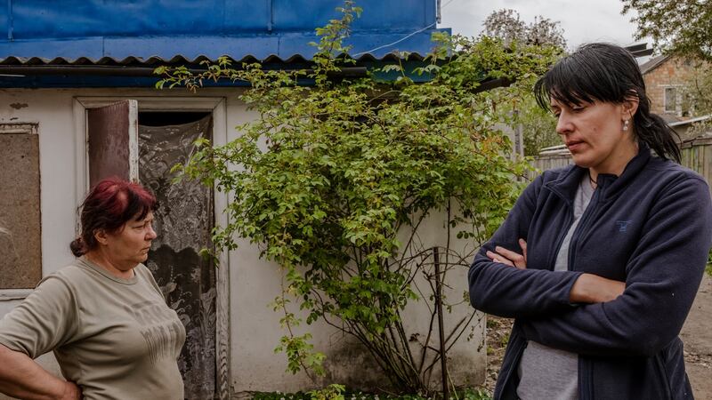 Olha Havryliuk with her daughter, Iryna Duhliy, in front of her home on May 8th, where her son and son-in-law, were found shot dead in the yard, along with a stranger, in Bucha. Photograph: Daniel Berehulak/The New York Times