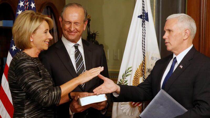 US vice-president Mike Pence concludes the swearing in of education secretary Betsy DeVos, joined by her husband Dick DeVos, at the White House on Tuesday. Photograph: Jonathan Ernst/Reuters