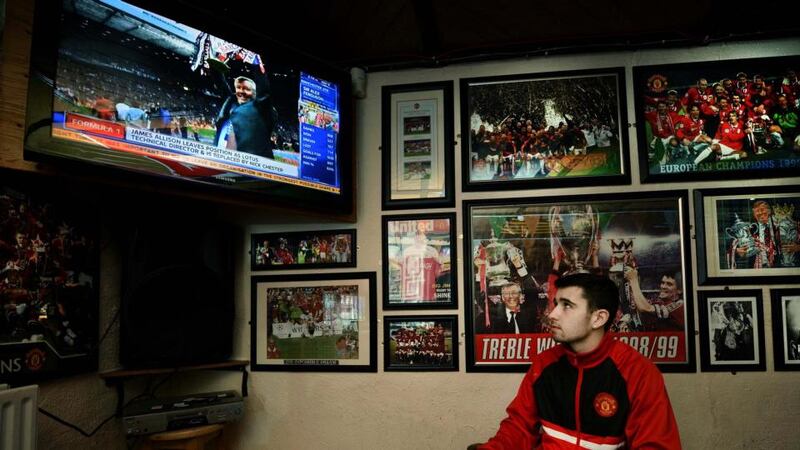 Manchester United fan Christopher Kearney sits in The Red Devil pub on Belfast’s Falls road watching the latest developments in the Alex Ferguson retirement story.