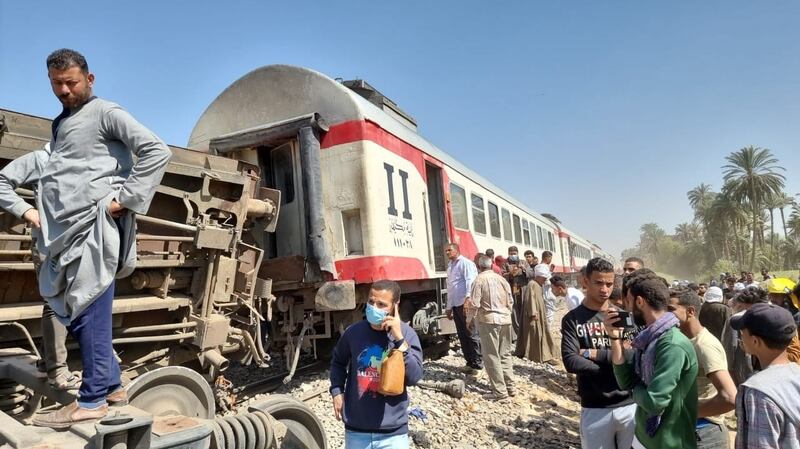 People inspect the scene of a train crash in Sohag province, Egypt. Photograph: EPA