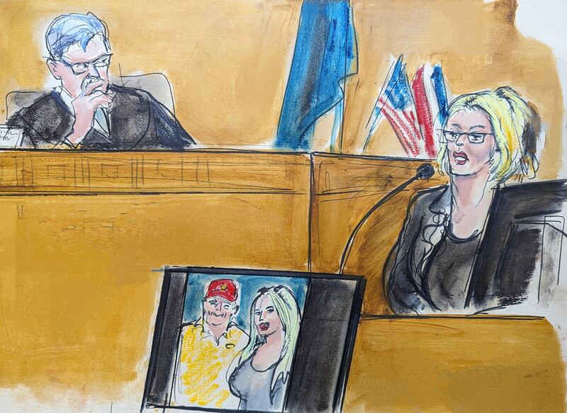 In this courtroom sketch, Stormy Daniels gives evidence as Judge Juan Merchan looks on. A photograph of Donald Trump and Daniels from their first meeting is displayed on a monitor . Photograph: Elizabeth Williams via AP