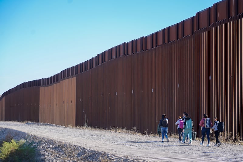 Unauthorised immigrants walk along the the US and Mexico border after crossing into the American side with the help of a Mexican cartel.  Picture: Enda O'Dowd