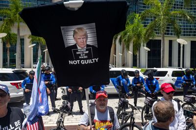 A supporter of former president Donald Trump carries a T-shirt as a banner outside the Wilkie D Ferguson courthouse in Miami, Florida. PhotograpH Christian Monterrosa/The New York Times
                      