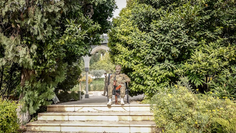 Rebel fighters outside Bashar al-Assad's presidential palace, which is now closed to the public