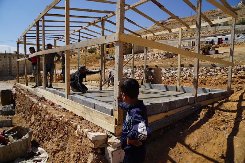 Syrian refugees in Arsal build a tent. Photograph: Hannah McCarthy