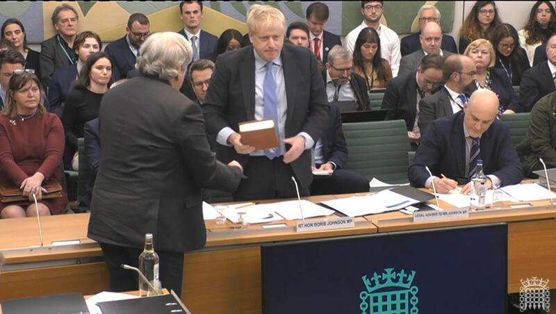 The clerk to the committee administers the oath to former prime minister Boris Johnson ahead of his evidence to the Privileges Committee at the House of Commons. Photograph: PA