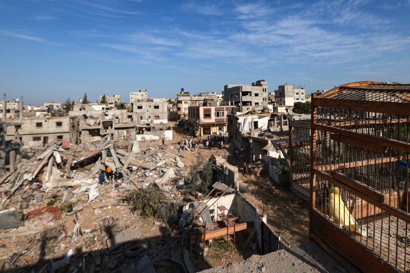 A bird sits in its cage as Palestinians inspect the damage in a residential building in Rafah in the southern Gaza Strip following Israeli air strikes. Photograph: Mohammed Abed/AFP via Getty