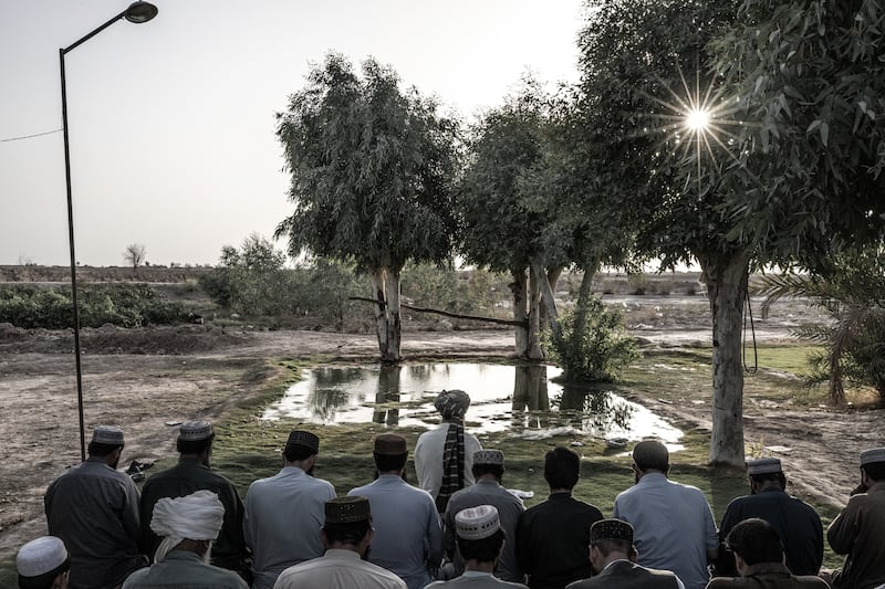 Men pray on a small patch of grass in Shagai, in southwest Afghanistan’s arid Bakwa district, on August 17th, 2023. Photograph: Bryan Denton/The New York Times