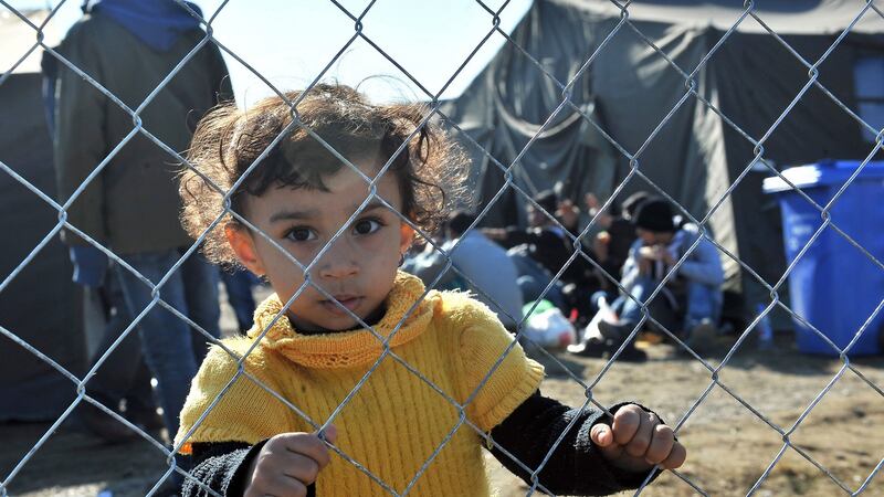 A girl holds on to a fence at a transit camp housing migrants and refugees in Slavonski Brod. Thousands of newly arrived migrants and asylum seekers are on the move through Croatia and towards the border with Slovenia, from where they plan to continue their journey to western European countries.  Photograph: Getty Images