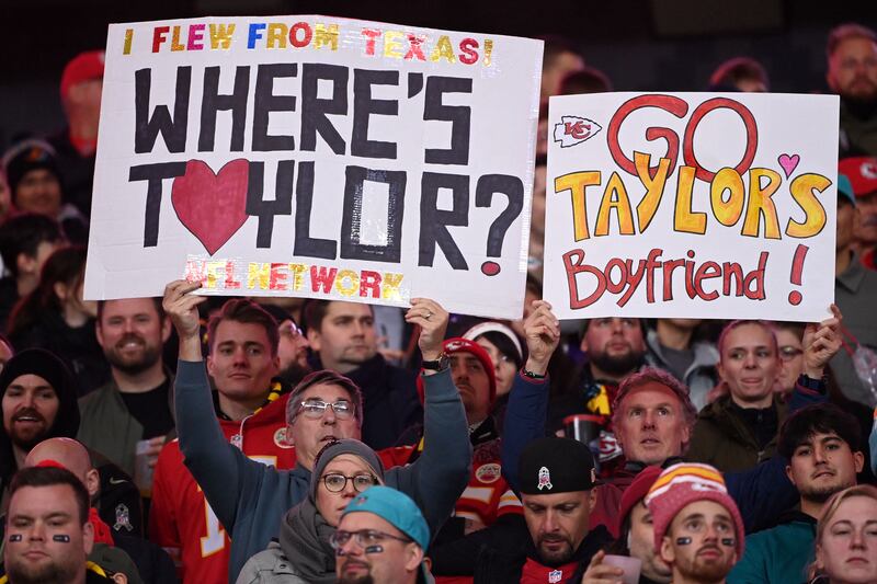 Fans hold up placards referring to Taylor Swift's boyfriend Kansas City Chiefs tight end Travis Kelce. Photograph: Kirill Kudryavtsev/AFP via Getty Images