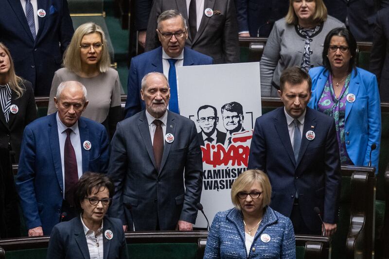 Members of the Law and Justice (PiS) display a placard reading 'Solidarity with Kaminski and Wasik' on the seats where the former minister for interior affairs Mariusz Kaminski and his deputy Maciej Wasik used to attend sessions. Photograph: Wojtek Radwanski/AFP via Getty Images