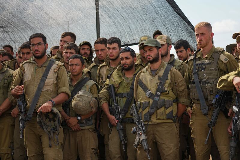 Israeli soldiers listen to Israel’s defence minister Yoav Gallant during his visit to a staging area near the border with the Gaza Strip in southern Israel. Photograph: AP