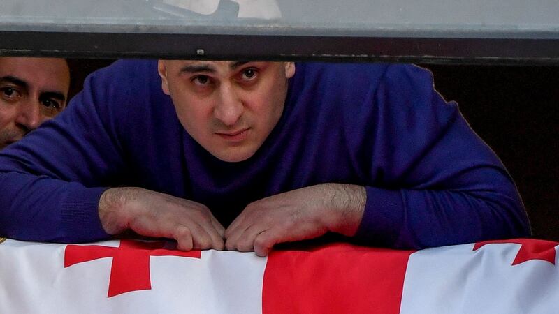 The leader of Georgia’s opposition United National Movement, Nika Melia, shouts from a window of the party’s headquarters as  police raided the building in Tbilisi. Photograph: Vano Shlamov/AFP via Getty Images