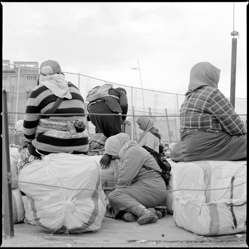 Morcoccan women wait with their packages at the Barrio Chino border crossing point in Melilla.