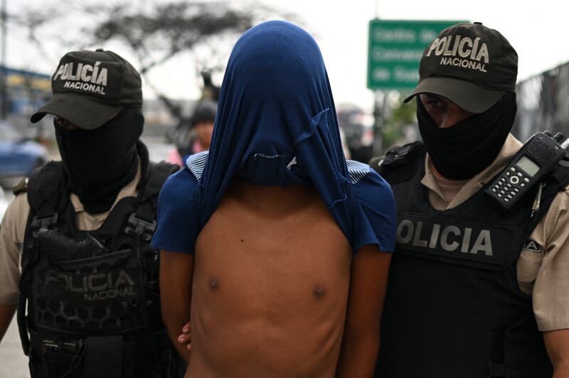 Ecuadorian police officers escort a man detained on suspicion of belonging to a criminal gang during an operation in Guayaquil on January 15th. Photograph: Yuri Cortez/AFP via Getty Images