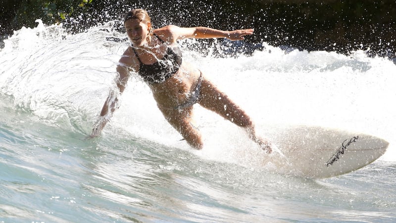 A woman surfs  on a wave along the Reuss river in the town of Bremgarten, Switzerland, at the weekend. Photograph: Arnd Wiegmann/Reuters