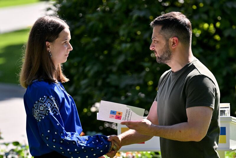 Ukrainian president Volodymyr Zelensky hands over a civil passport, a document issued to citizens when they reach the age of 16, to children of Ukrainian servicemen killed in action against Russian troops 