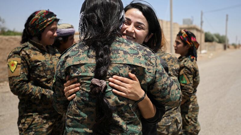 A Syrian Democratic Forces (SDF) fighter embraces a field commander near Raqqa city, Syria. Photograph: Rodi Said/Reuters