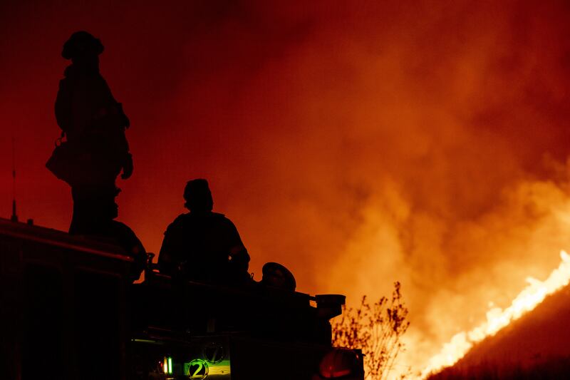 Firefighters observe from a firetruck as fire takes hold north of Los Angeles last week. Photograph: Jill Connelly/Bloomberg