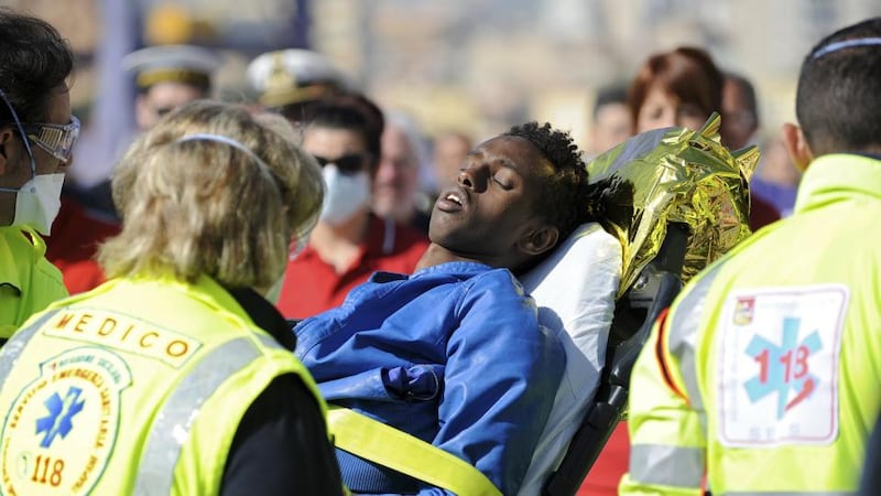 A man is helped as he disembarks from a Coast Guard boat in the Sicilian harbour of Palermo  on Sunday. The death toll from Sunday’s shipwreck off the coast of Libya was uncertain after officials said there had been at least 700 people on board, some reportedly locked in the hold. Photograph: Guglielmo Mangiapane/Reuters