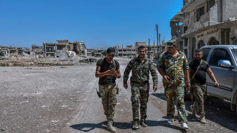 Syrian army soldiers patrol the street in Khan Sheikhoun city. Photograph: Syrian Arab News Agency