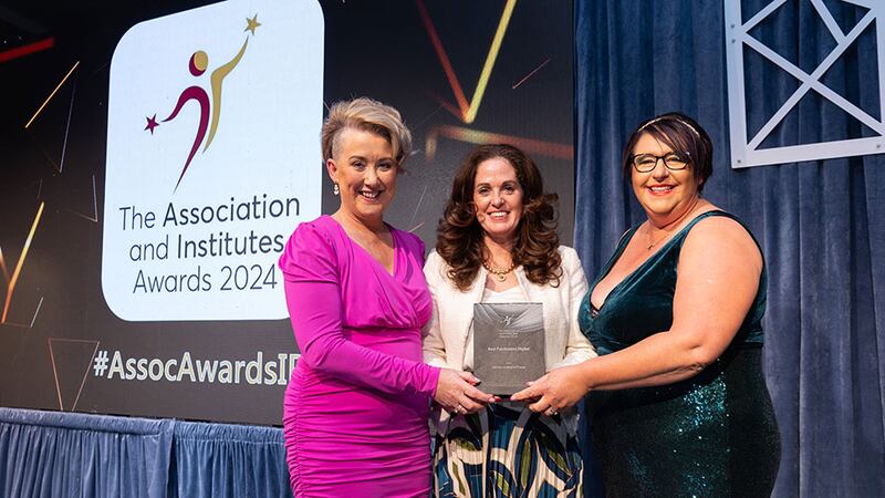 Angela Guillemet, awards judge, presents the best publication digital awards to Judith McNamee and Margaret McLaughlin, Woven