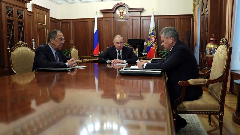 Russian president Vladimir Putin speaks with defence minister Sergei Shoigu (right) and foreign minister Sergei Lavrov (left) during their meeting at the Kremlin in Moscow. Photograph: Michael Klimentyev/AFP/Getty Images