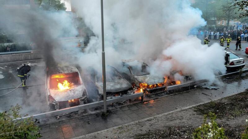 Firemen extinguish a row of burning cars in the Stockholm  suburb of Rinkeby after youths rioted in several different suburbs around the Swedish capital. Photograph: Fredrik Sandberg/Scanpix/Reuters