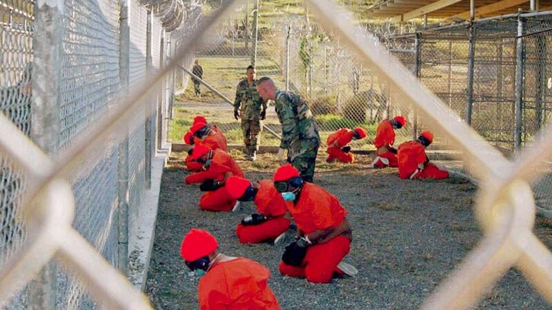 A file photograph shows detainees sitting in a holding area watched by military police at Camp X-Ray inside Naval Base Guantanamo Bay, Cuba, during their processing into the temporary detention facility on January 11th, 2002. Photograph: US Department of Defense/Shane T McCoy/Handout/Reuters