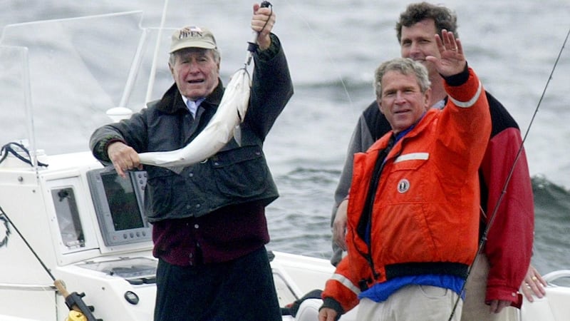 A file photo taken in  2003 shows former US president George W Bush (right) waving as he fishes with his father, former US president George HW Bush (left). Photograph: AFP