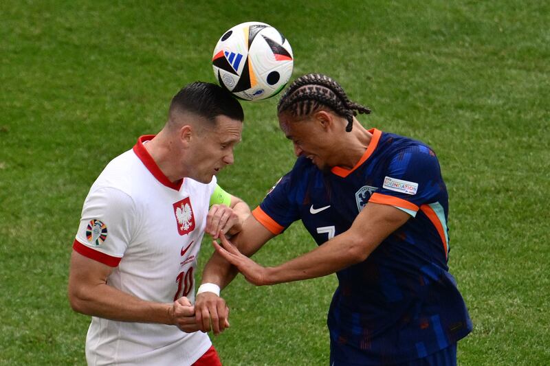 Poland midfielder Piotr Zielinski fights for the ball with Netherlands forward Xavi Simons during the Euro 2024 Group D match in Hamburg. Photograph: Christophe Simon/AFP via Getty Images