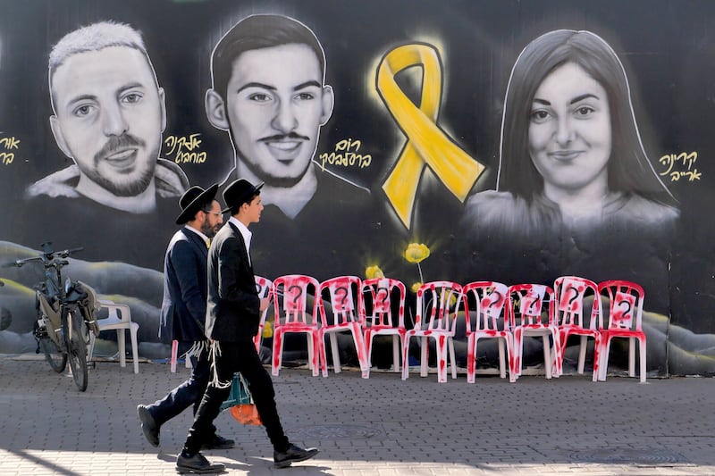 Ultra Orthodox Jews walk past a mural in Jerusalem this week depicting Israeli hostages held by Hamas in Gaza. Photograph: Abir Sultan/EPA-EFE