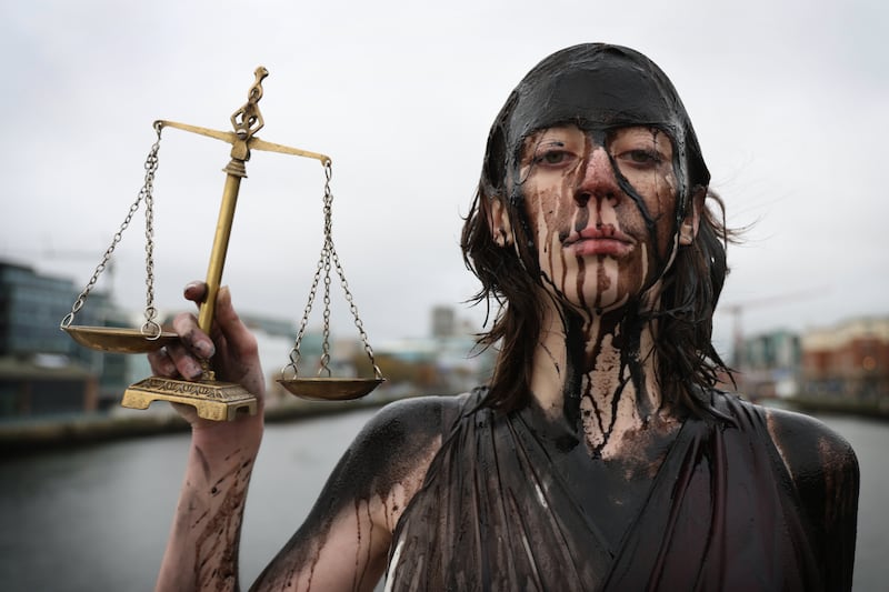 On the eve of  the UN Conference of Parties (COP) in Baku, Stop Climate Chaos organised a visual stunt in Dublin with Lady Justice, (played by Gemma Roche) being drowned in oil to represent the inequality of the transition from fossil fuels. Photograph: Bryan O’Brien/The Irish Times


