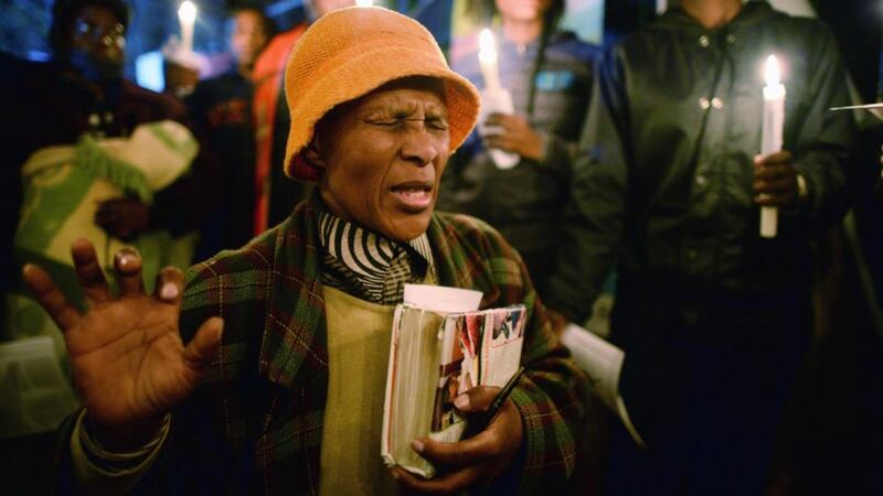 A woman kneels and prays for Nelson Mandela outside the Mediclinic Heart Hospital where he is being treated. People continue to gather and lay flowers and tributes outside the Mediclinic Heart Hospital where the former South African president is being treated for a lung infection. Photograph: Jeff J Mitchell/Getty Images