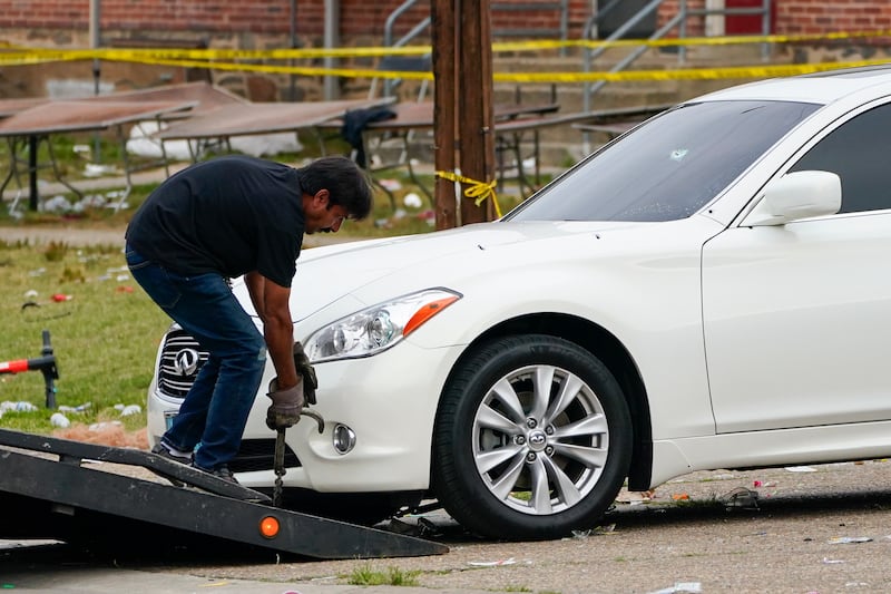 A tow truck operator removes a vehicle with multiple bullet holes near the area of the mass shooting incident in Baltimore. Photograph: Julio Cortez/AP