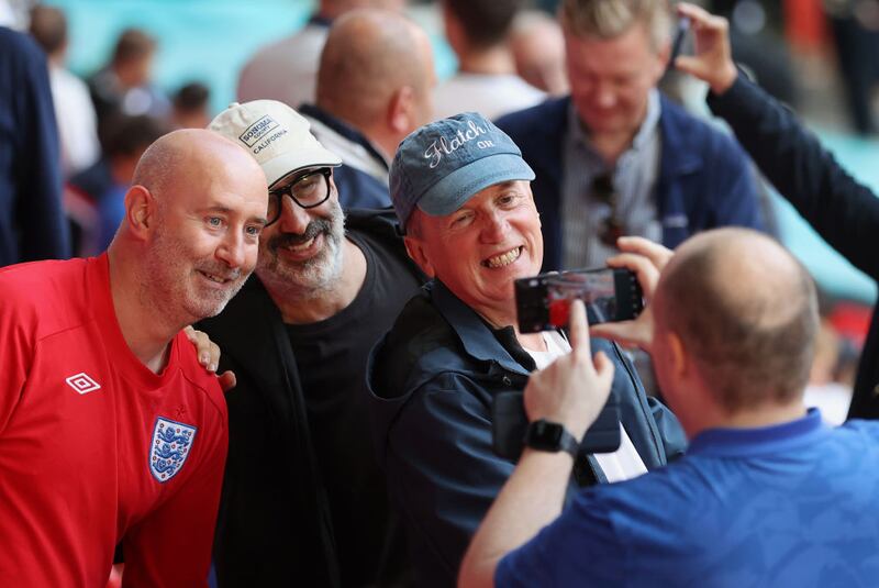 David Baddiel and Frank Skinner take a selfie with fans in the crowd during the UEFA Euro 2020 Championship semi-final. Photograph: Catherine Ivill/Getty Images