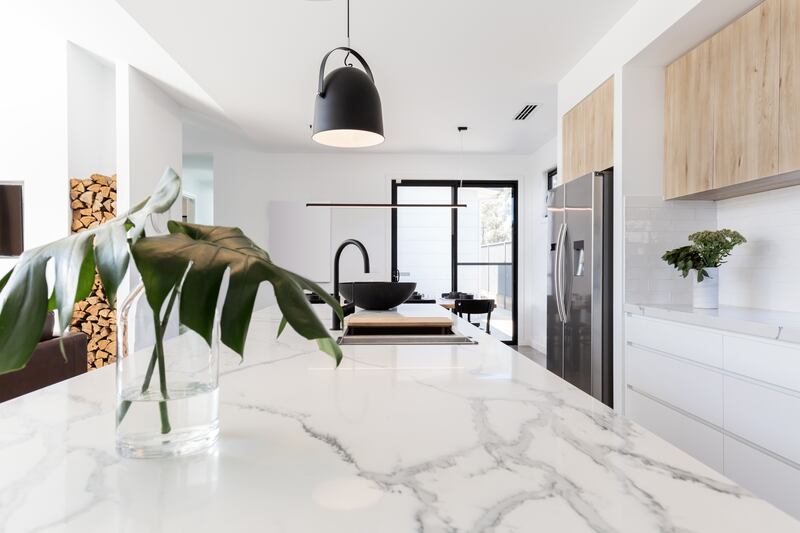 Kitchen marble bench with black hanging pendant and vase. Photograph: iStock