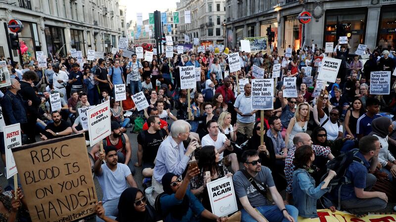 Demonstrators sit in the road in Whitehall during a protest following the fire that destroyed the Grenfell Tower block. Photograph: Stefan Wermuth/Reuters