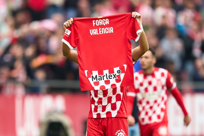 Miguel Gutierrez of Girona FC shows a shirt with a message in support of Valencia after the flash flooding in the Valencia region. Photograph: Alex Caparros/Getty